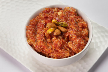 Delicious gajar ka halwa kept in a white bowl. 

