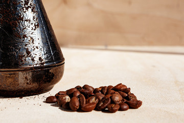 Morning coffee concept. Turkish coffee in Turk and coffee beans on a wooden countertop.