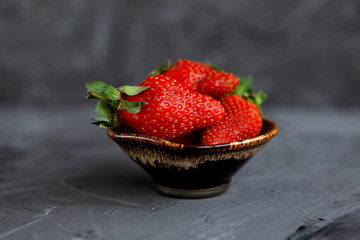 Ripe red strawberries. Bowl filled with juicy fresh ripe red strawberries. strawberries on a grey concrete table. Fresh strawberries photo. Сoncept healthy food