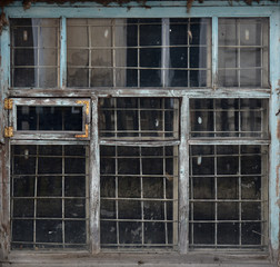 Fototapeta na wymiar Old wooden window behind a metal grate. Vintage texture