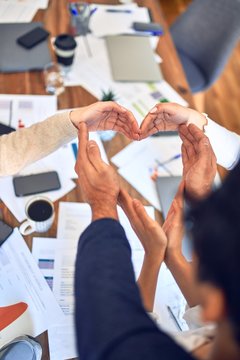 Group of business workers standing with hands together doing symbol at the office