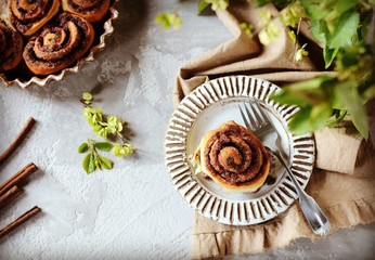 Cinnamon buns in a plate on a gray background, still life