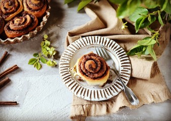 Cinnamon buns in a plate on a gray background, still life