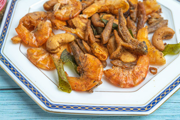 Thai food, Fried Crispy shrimp with herbs and spices on old ceramic dish with Blue Wooden Background , Flat Lay Out, Top View Angle