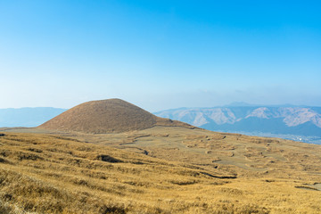 Komezuka in January, a volcanic cone in Aso Kuju National Park. A grass field covers the surrounding area and the surface of it. Kumamoto Prefecture, Japan