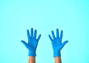 Human rising hands wearing blue disposable latex glove, rubber glove for professional medical safety and hygiene protection from Coronavirus disease COVID-19 and surgery and medical exam