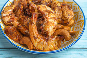 Thai food, Fried Crispy shrimp with herbs and spices on old ceramic dish with Blue Wooden Background , Flat Lay Out, Top View Angle