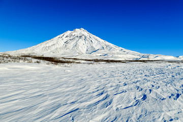 Fototapeta na wymiar Winter Volcanos in Kamchatka with fuming tops