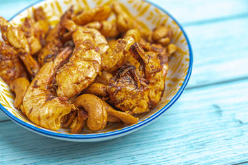 Thai food, Fried Crispy shrimp with herbs and spices on old ceramic dish with Blue Wooden Background , Flat Lay Out, Top View Angle