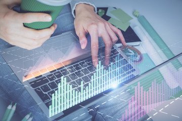 Double exposure of woman hands typing on computer and forex chart hologram drawing. Stock market invest concept.