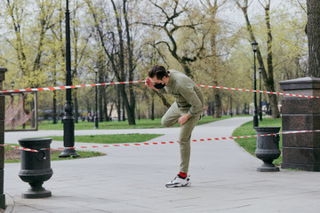 Obraz premium A man climbs over the fence. Violation of the ban on movement in parks and squares. Coronavirus