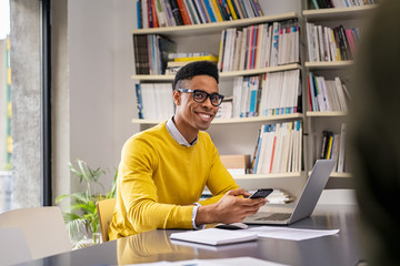 Happy young black business man at work