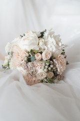 Wedding bouquet of white, green and pink flowers on a light background