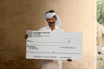 Indian rural man showing a bank cheque
