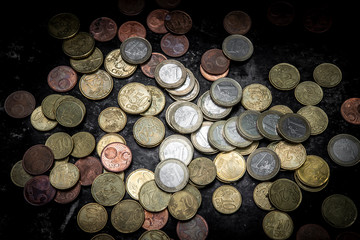 pile of euro coins with high contrast and bright lighting seen from above with a black background
