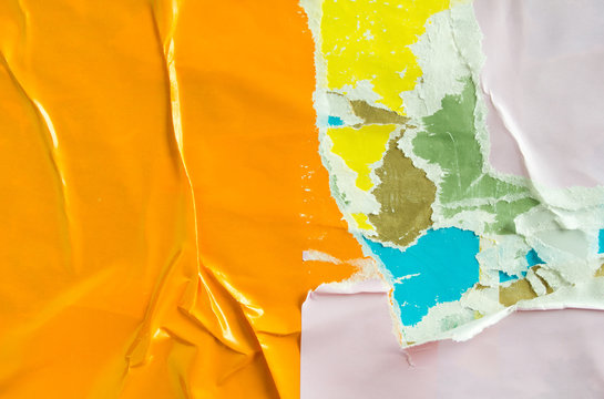 Orange and white torn and crumpled placards on urban billboard with old ripped and peeling paper posters texture background.