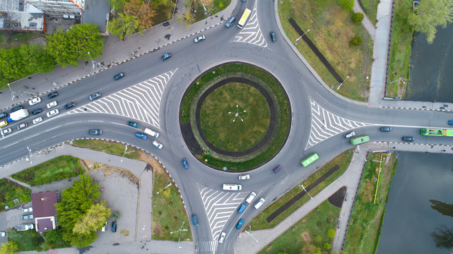 Ring Road From The High With Green Grass Circle Inside And Cars Traffic.Aerial View Of Highway Interchange In  City,