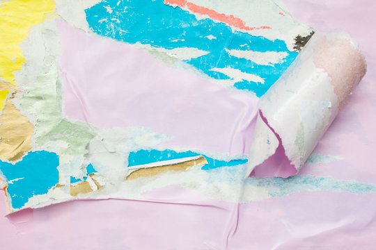 Pink torn and crumpled paper poster on billboard with old dirty ripped and peeling paper placards texture background.