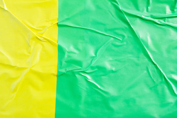 Yellow and green crumpled glossy paper placard and poster texture background.