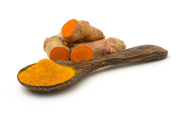 Turmeric powder in a wooden spoon and fresh turmeric (curcumin) rhizome isolated on a white background,copy space.