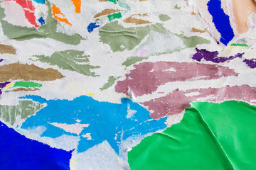 Urban wall with old dirty torn and peeling paper placards and posters texture background.