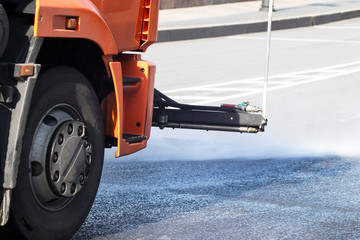 The car washes the streets, asphalt in the city. Road disinfection during coronavirus, covid-19....
