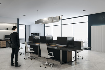 Businessman standing in coworking office interior