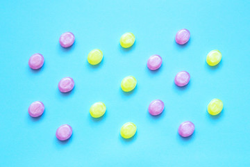 Multicolored candy on a colored background. Flat lay