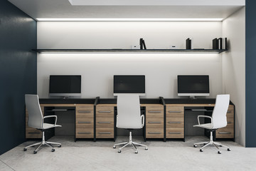 Modern coworking office interior with three computers