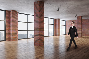 Fototapeta na wymiar Businessman walking in contemporary red brick room