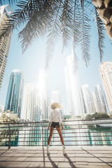 Bright and clean overlooking lake view in an urban city emirates gulf country lifestyle. Russian lady motion photography in the city with tall building in surroundings.