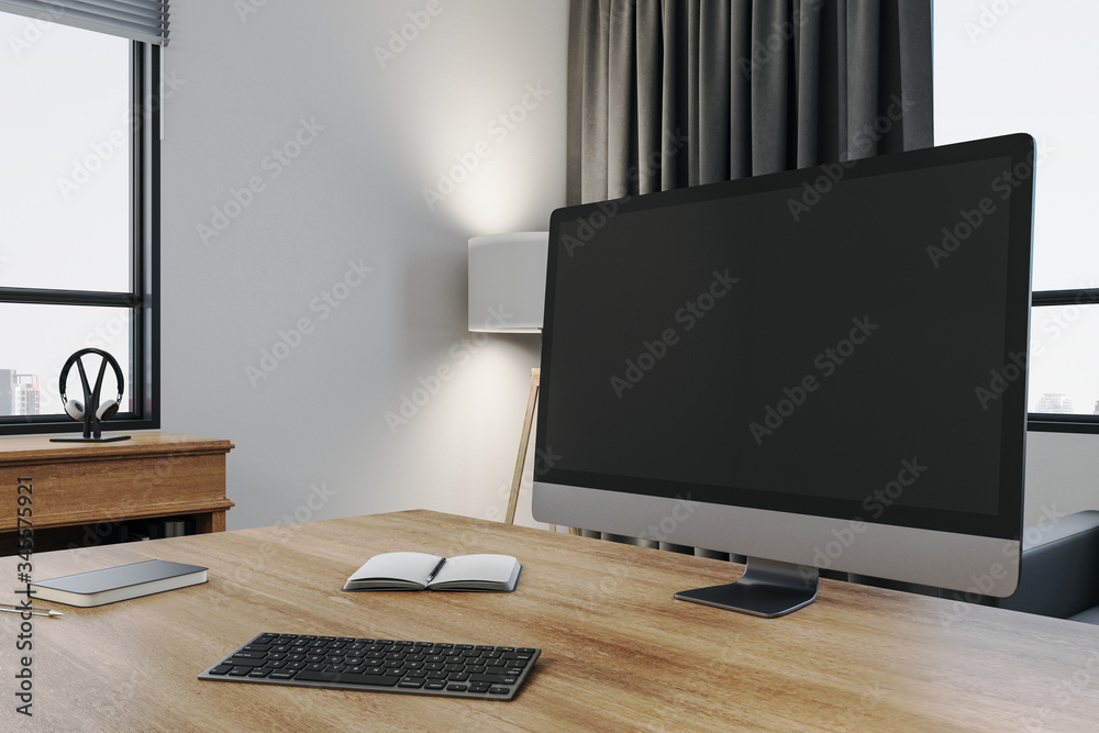 Poster designer workplace with empty black computer screen and supplies.