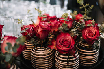 photo of red roses on a table in a vase