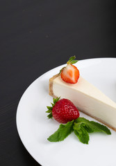 cheesecake on a plate on a black background