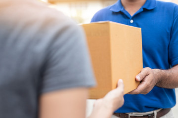 Woman hand accepting a delivery boxes of paper containers from deliveryman.