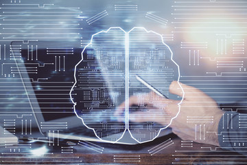 Double exposure of man's hand holding and using a digital device and brain hologram drawing. Data...