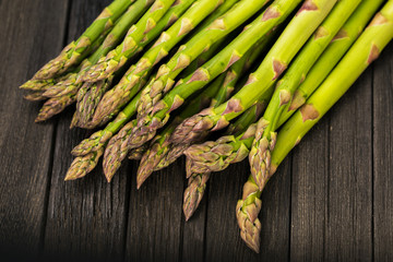 Bunch of fresh green asparagus spears on a rustic wooden table