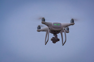 Drone is flying with digital camera to take photo and video on ground at sunset time.