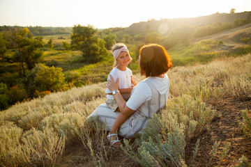 Happy mother and daugther enjoiyng in field in sunny day