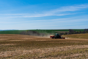 Farmer in tractor sowing wheat field at spring , czech jeseniky 04.16.2020