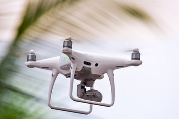Drone is flying with digital camera to take photo and video on ground at sunset time.