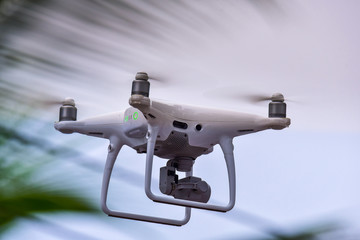 Drone is flying with digital camera to take photo and video on ground at sunset time.