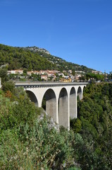 Fototapeta na wymiar Road from Nice to Italy. View from the Moenne Kornice scenic road to the viaduct (stone Arch bridge) near the Eze village.