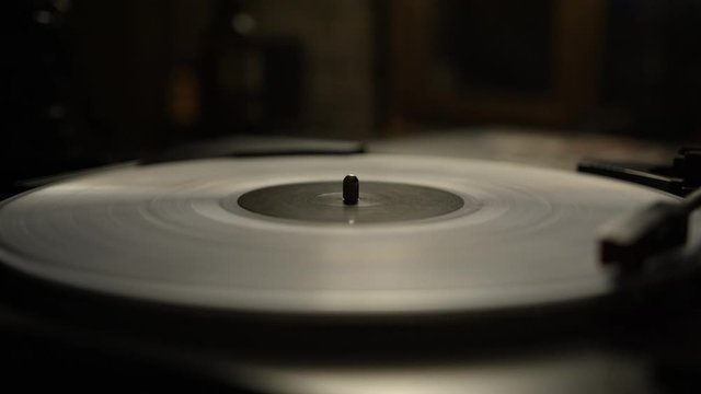Putting a white vinyl record on turntable and putting stylus needle on