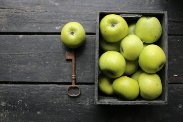 Ripe green apples box on wooden table. Top view with space for your text