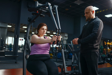 Fototapeta na wymiar Overweight woman doing exercise in gym