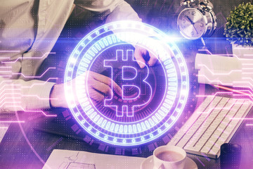 Double exposure of man's hands holding and using a phone and crypto currency blockchain theme...