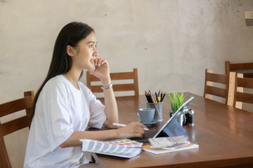 Portrait of young asian female designer or photographer working with tablet at home office, working from home concept.