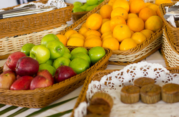 Fruits on the table. Apples and tangerines in a wicker basket.