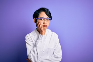 Young beautiful asian scientist girl wearing coat and glasses over purple background thinking looking tired and bored with depression problems with crossed arms.